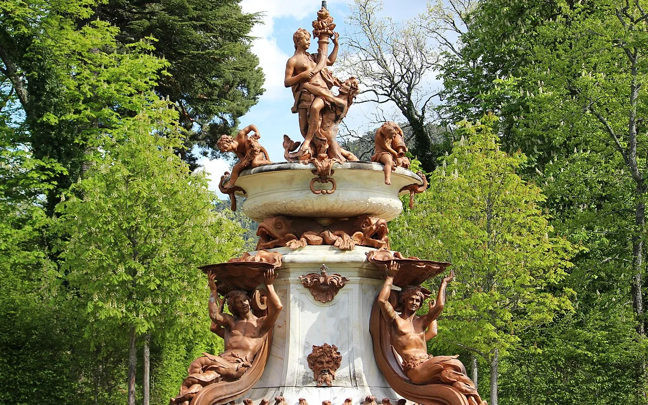 A sculpted Baroque fountain group among the trees of the garden